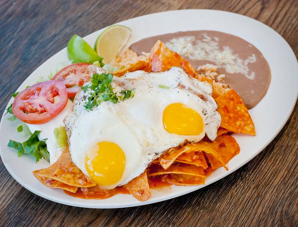 Chilaquiles con Huevo · Fried corn tortilla with eggs. Served with rice, beans, lettuce, guacamole, and sour cream. 