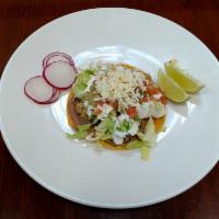 Tostada  · Crispy tortilla with choice of meat, beans, lettuce, cheese, onions, cilantro, sour cream, g...