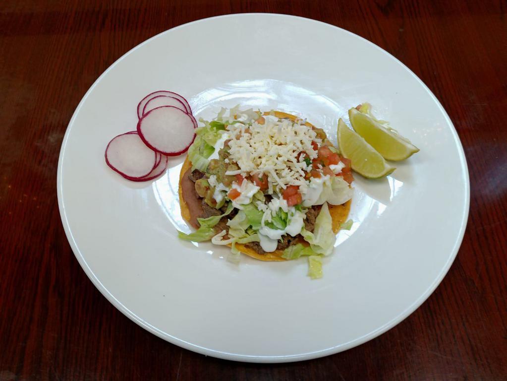 Tostada · Crispy tortilla with any meat, beans, lettuce, cheese, onions, cilantro, sour cream, guacamole and salsa.
