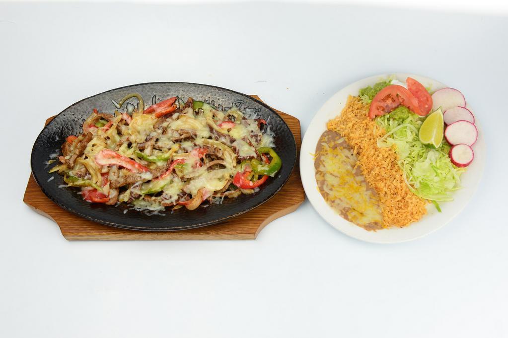 Alambres · Chunks of beef steak, onions, bell pepper, bacon, rice, beans, sour cream, guacamole, salad and tortillas.
