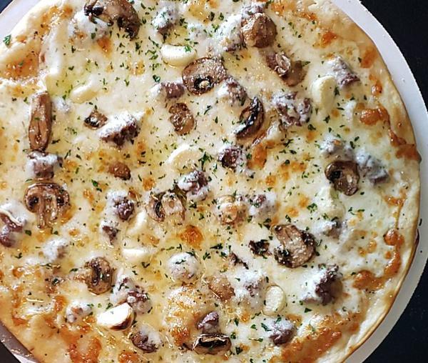 Steak de Burgo Pizza · Gluten free option available. A new twist on an old Des Moines fave. A white pizza crust brushed with de Burgo oil and topped with mozzarella cheese, mushrooms, roasted garlic cloves and tender steak.
