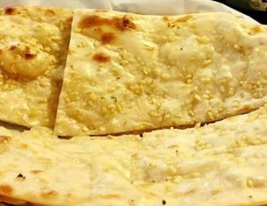 Garlic Naan · Soft and fluffy Indian flatbread infused with garlic flavor. Vegetarian.