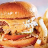 The Burger · Two 1/4 lb. patties, topped with lettuce, tomatoes, pickles, melted American cheese and Parr...
