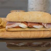 Parma Italiano Sandwich · Prosciutto, mozzarella, tomato, and pine nuts pesto on ciabatta.
