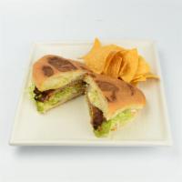 Torta de Milanesa · Toasted Mexican bread with refried beans, cheese, sour cream, tomato, lettuce and guacamole. 