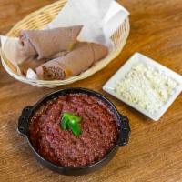 Kitfo · Beef tartar seasoned with kibe (Ethiopian butter), mitmita (chili powder), and spices. Comes...