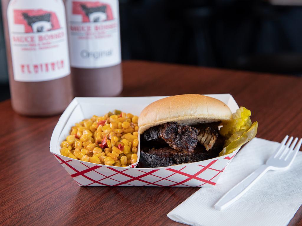 Brisket Sandwich · Beef brisket rubbed down with a Texas style rub.  Then cooked over a wood fire of oak wood.  Sauce served on the side.