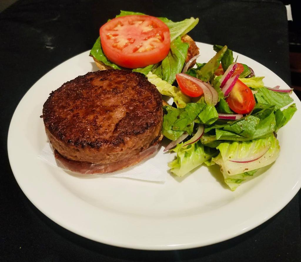 Vegan Burger · Plant-based protein patty served with a side salad.
