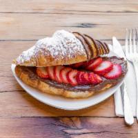 Strawberry Nutella Croissant · Croissant filled with Nutella and fresh strawberries drizzled with Nutella on top.