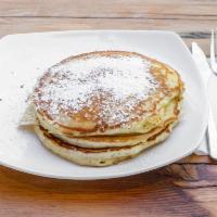 Homemade Pancakes · Stack of three original buttermilk pancakes with powdered sugar coating and maple syrup.