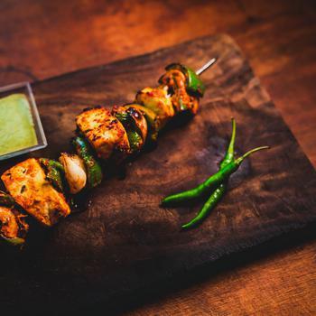 Tandoori Paneer Tikka · Cottage cheese marinated in cashew & cheese paste, cooked in tandoor to perfection, served with coriander chutney