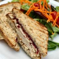 Turkey and Brie Sandy · roast turkey, warm brie, cranberry compote, champagne mustard, toasted whole wheat
