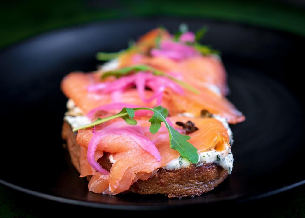 Smoked Salmon Toast · Dill cream cheese, smoked salmon, fried capers, pickled onions and lemon zest. On sourdough.