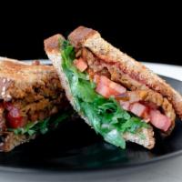 Vegan BLT · Tempeh bacon, arugula, and tomato with Dijon on multigrain pan loaf.