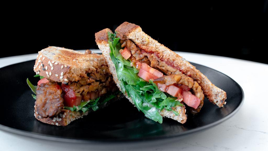 Vegan BLT · Tempeh bacon, arugula, and tomato with Dijon on multigrain pan loaf.