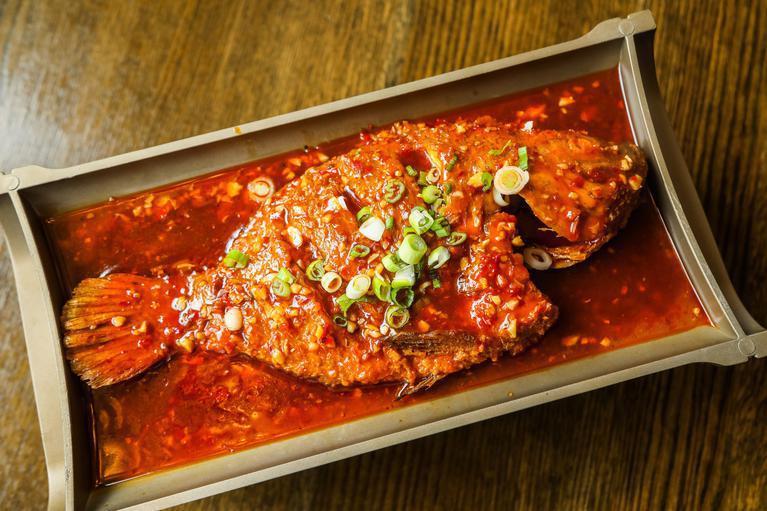 Braised Whole Fish with Bean Paste Sauce · Unlike the flamingly hot roast whole fish, this braised fish is significantly milder and lightly sweet. Tilapia. Spicy. Rice not included 
