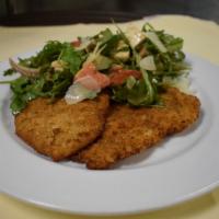Chicken Milanese · Breaded cutlets of chicken topped with arugula and tomato salad with fresh mozzarella dresse...