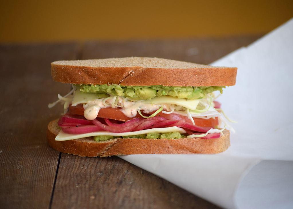 Veggie Baja Sandwich · Avocado, shaved cabbage, pickled red onions, tomato, pepper jack cheese, a chipotle honey lime yogurt sauce, and salt & pepper mix. Fresh made on Honey Whole Wheat bread. 