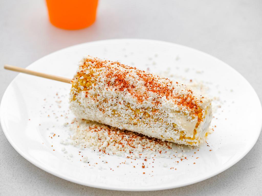 Elote · Corn cob on a stick covered with mayo, sour cream, cotija cheese, and chili powder.