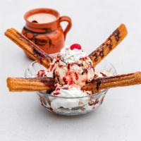 Val Sundae · 2 small churros with 1 ice cream scoop, topped with whip cream, strawberry, chocolate, and c...