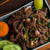 Nam-Tok · Sliced, grilled flank steak, red onions, green onions, cilantro and toasted rice powder in a...