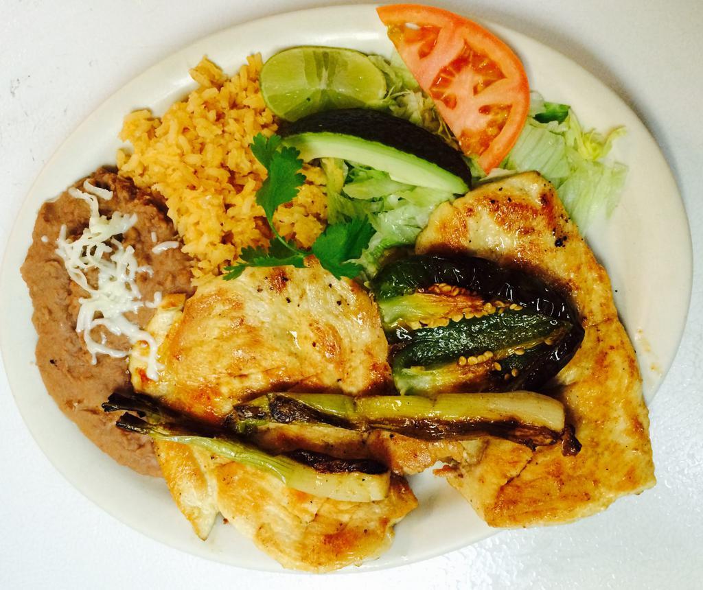 Pechuga a La Plancha · Chicken breast with rice, refried beans and salad.