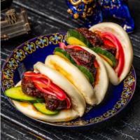Spicy Pork Bao · Fried sous vide pork coated in our dragon sauce with a base of cucumber and topped with pick...