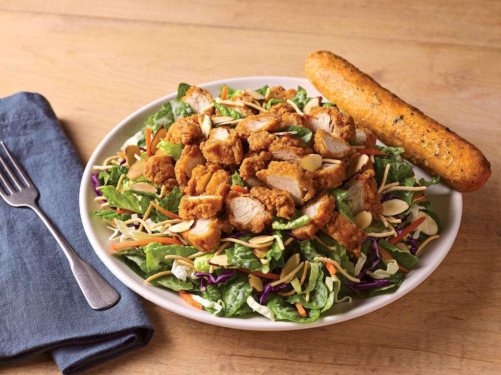 Oriental Chicken Salad · A long-running favorite, crispy  breaded chicken tenders top a bed of Asian greens, rice noodles and almonds tossed in our Oriental vinaigrette.