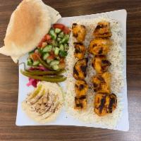Chicken Tikka Combo · 2 skewer of Chicken on top of a nice portion of rice, Green salad, and hummus on the side wi...
