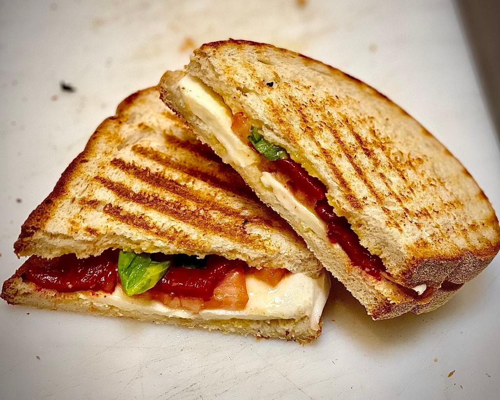 Caprese Panini · Fresh mozzarella, roasted red peppers, tomatoes, and fresh basil. Served on Italian ciabatta bread without lettuce.