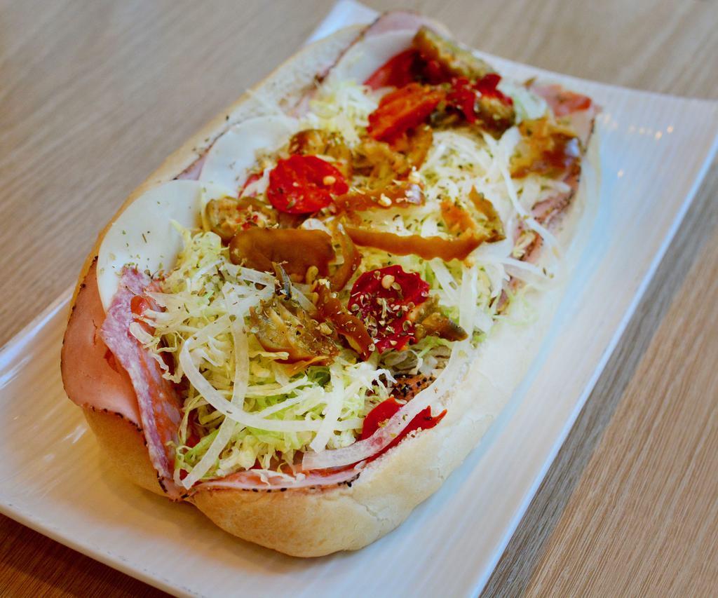 The Spicy Italian Sub · Spiced capicola ham, prosciuttini ham, provolone, Genoa salami, and hot peppers. Topped with hot peppers, lettuce, onion, sweet peppers, and oil and vinegar dressing.