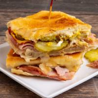 Sandwich Cubano · A delicious Cuban sandwich made of regular ham, pork ham, Swiss cheese, pickles, mustard and...