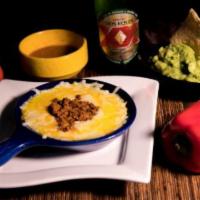 Queso Fundido · Melted cheese with choice of Mexican sausage or beans. Con opcion de chorizo o frijol arriba.
