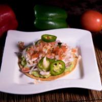 Tostada · Beans, lettuce, tomato, onions, avocado, sour cream, and grated cheese on top, jalapeno upon...