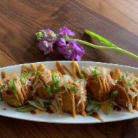 A6. Takoyaki (5) · Fried octopus balls with cabbage, green onions, yam and soy bean oil. Topped with mayo sauce.