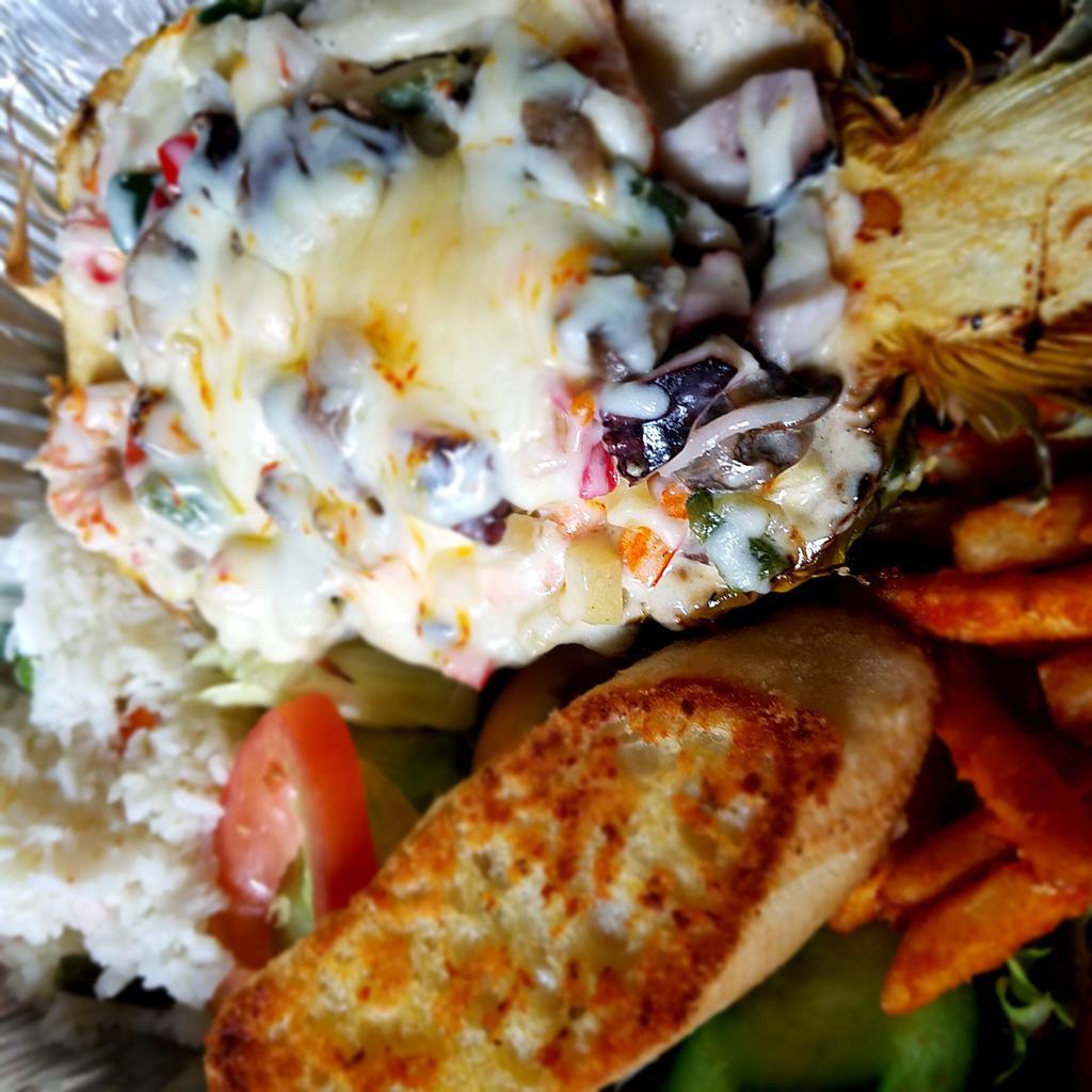 Pina Rellena · Stuffed pineapple. Combination of seafood sauteed and baked with crab, octopus, shrimp, scallops, mixed sweet peppers, mushrooms and cheese. 