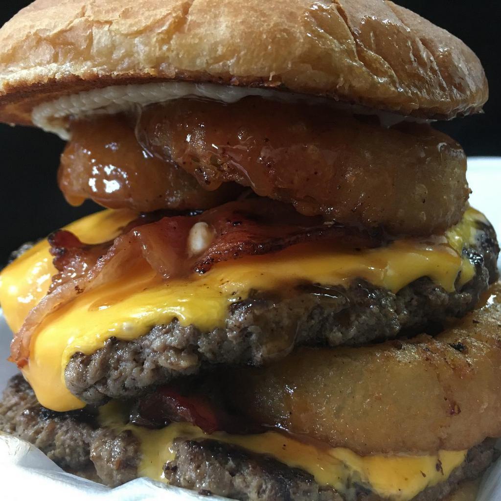 Big D Westerner Burger · Ground beef patty, seasoned to perfection, topped with 2 slices of cheese, savory bacon, two crispy onion rings mayo and BIG DaVe'S signature sauce.