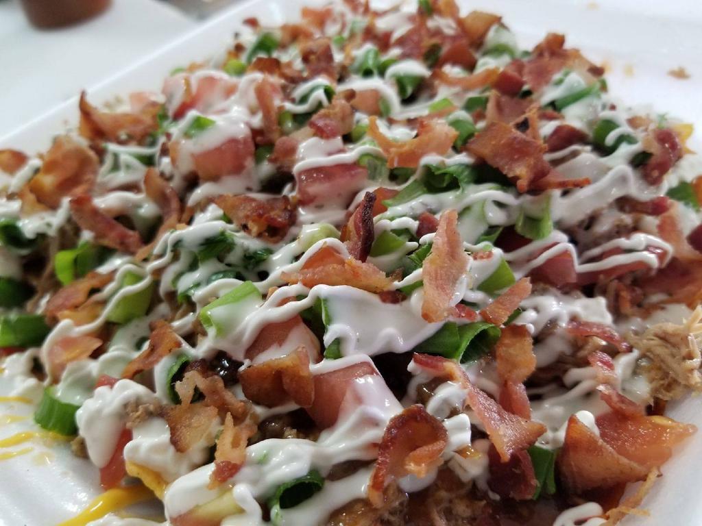 Big D Nachos · Crunchy nacho chips smothered in melted cheese, topped with your choice of either chopped beef, chopped chicken, or pulled pork, diced tomatoes, green onions, and sour cream with Big Dave's signature sauce.