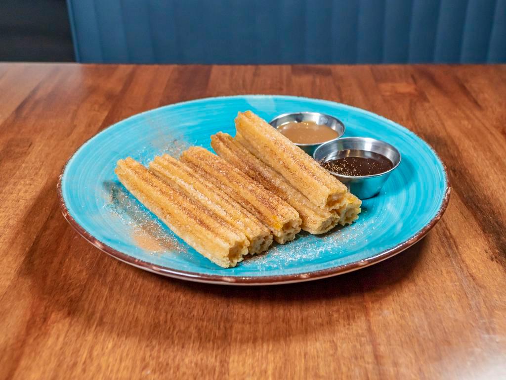 Spanish Churros · Cinnamon Sugar dusted Churros. Served with Chocolate and Caramel dipping sauce.