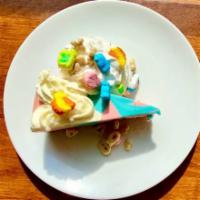 Lucky Charms Cheesecake · Cotton Candy Swirl Cheesecake Topped with Crumbled Graham Cracker and Lucky Charms Cereal.
