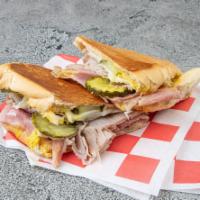 The Cuban Cuban Sub · Freshly sliced deluxe ham, sliced pork, and melted Austrian Swiss. Topped with pickles, must...