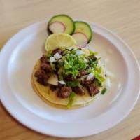 Carne Asada Mini Taco · Grilled steak mini taco topped with onion and cilantro. Served with grilled onions and jalap...