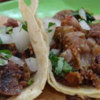 Tripa Mini Taco · Tripa mini taco topped with onion and cilantro. Served with grilled onions and jalapeno on t...