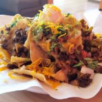 Carne Asada Nacho · Crunchy chips topped with carne asada, refried beans, guacamole, sour cream, and cheese 
