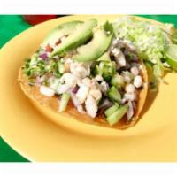 Tostada De Ceviche · Shrimp cooked in lime juice with tomato, onion, and cilantro. Topped with avacado. 