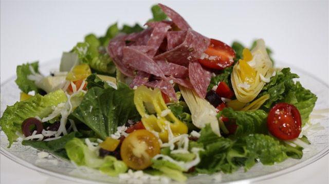 Italian Salad · Chopped romaine, red peppers, salami, mozzarella, Kalamata olives, tomatoes, artichoke hearts, pepperoncinis, Italian dressing. Served with sourdough croutons.