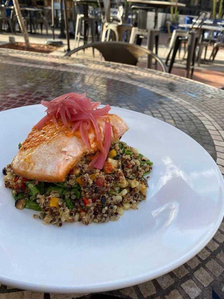 Salmon · Seared salmon, quinoa, red and yellow peppers, arugula, roasted corn, ancho pepper sauce, pickled onion