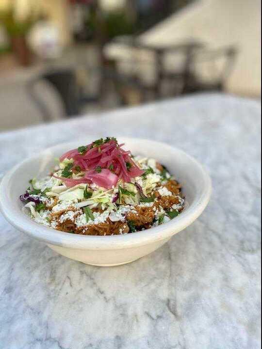 Baja Bowl · Chipotle and tomato braised chicken, cabbage, chipotle aioli, pickled onions, cotija, cilantro, spanish rice, black beans