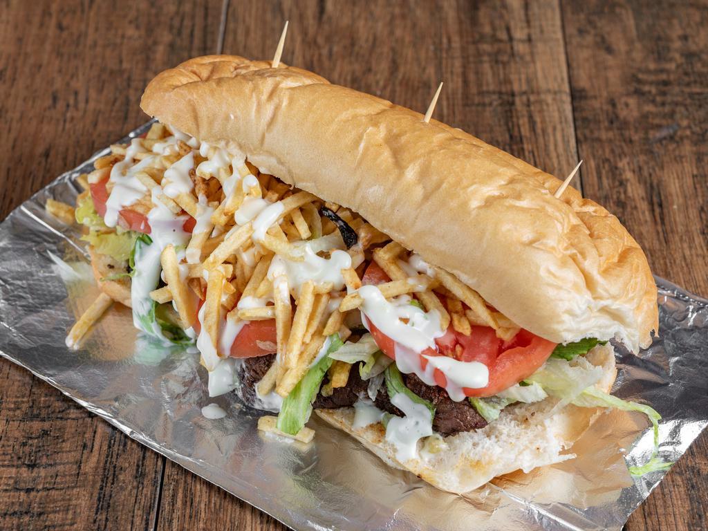Cuban Steak Sandwich · Built with Palomilla steak, grilled onions, tomato, lettuce, potato sticks, and Cuban-style mayo in toasted Cuban bread.