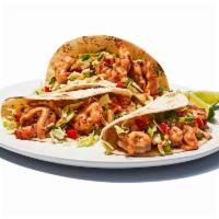 Baja Shrimp Tacos · We grill seasoned shrimp, then wrap them in flour tortillas with an un-shrimp amount of cabb...